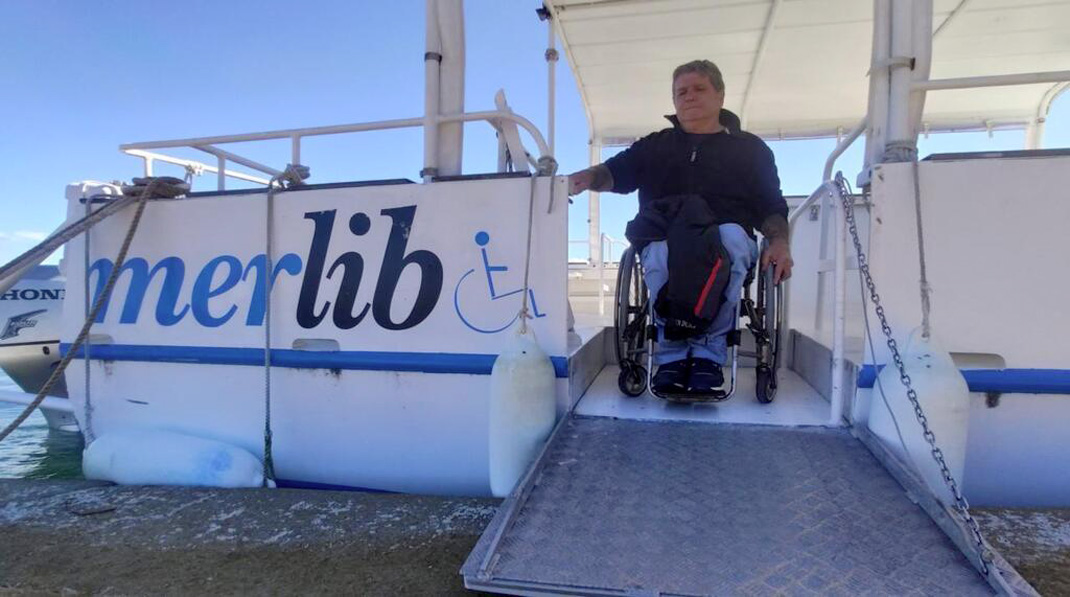 bateau à quai avec une personne descandant en fauteuil roulant